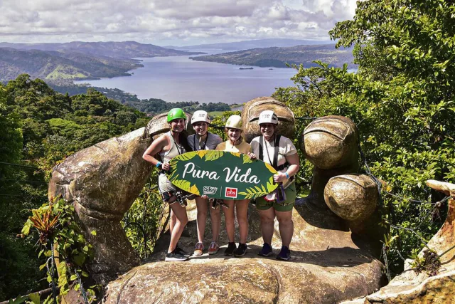 Travelers holding a Pura Vida sign in Arenal Volcano area