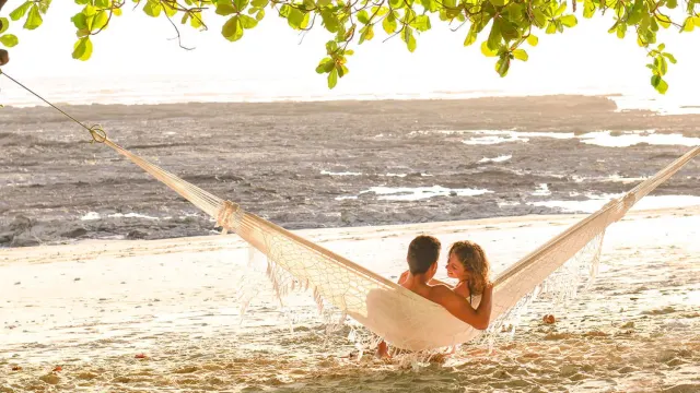 Couple resting in a hammock at the beach
